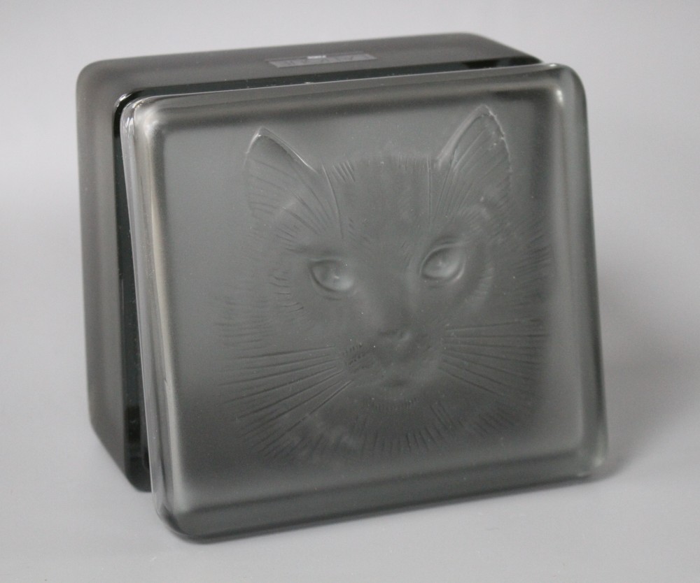 A modern Lalique smoky green tinted glass box, decorated with a cats head, 11 x 9.5cm, height 5cm, with original box